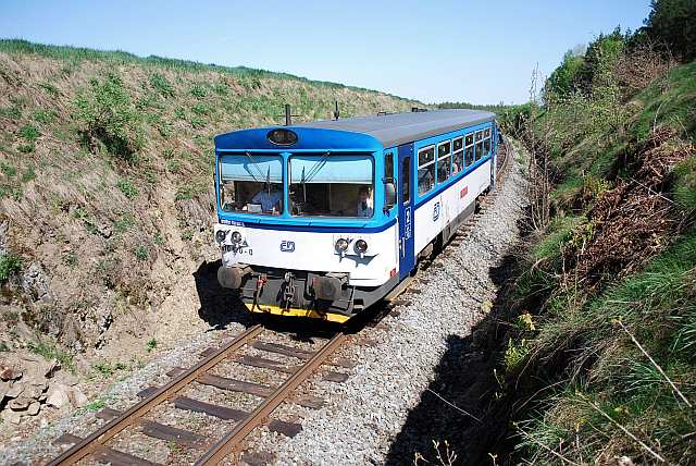 Motorový vůz 810.670 v novém nátěru ČD projíždí zářezem za zastávkou Blahousty.